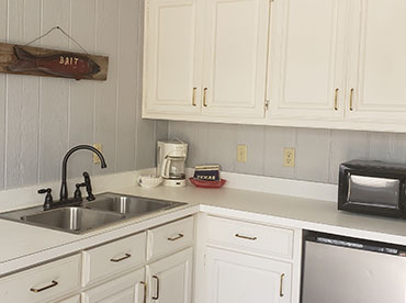 Interior of the duplex showing the kitchen complete with sink, microwave, coffee maker and stainless steel dishwasher