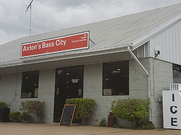 Outside of convenience store with ice machine next to building on a cloudy, spring day